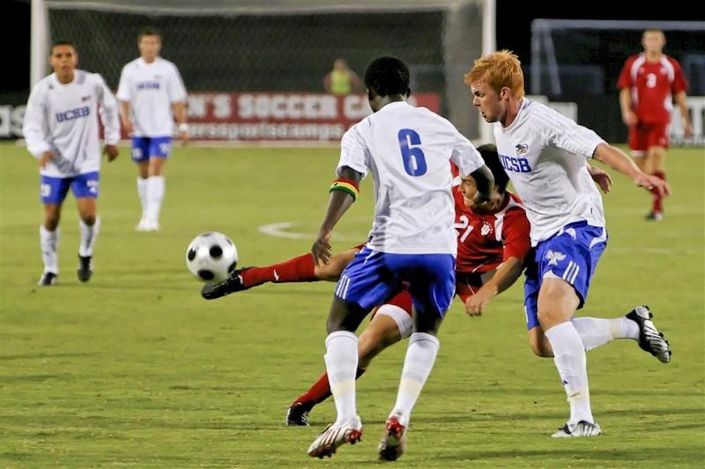 Sophomore midfielder Daniel Kelly makes a pass while battling two UCSB defenders during the Hoosiers' 2-1 loss to the Gauchos Friday night at Bill Armstrong Stadium.