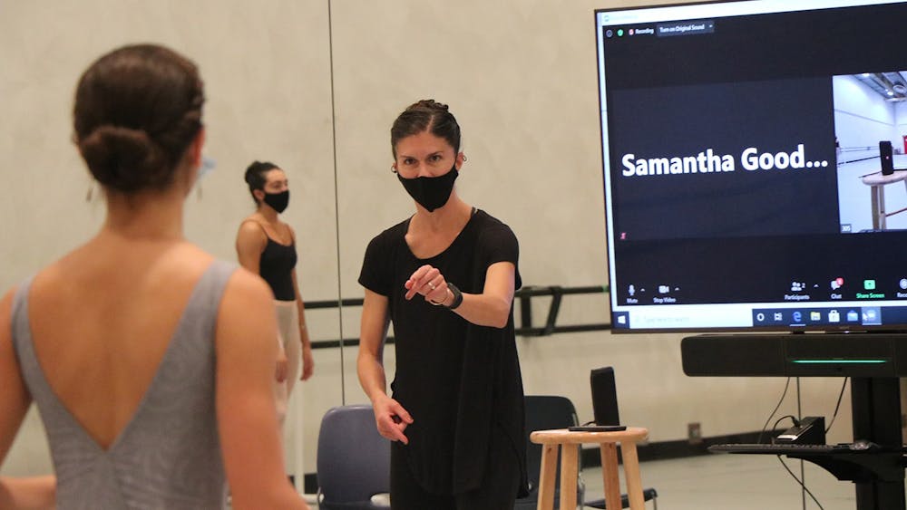 10月1日，在音乐艺术中心，iu芭蕾舞系系主任Sarah Wroth正在向一名芭蕾舞学生讲解技巧。通过在Zoom电话前授课，愤怒适应了隔离学生的面对面课堂。