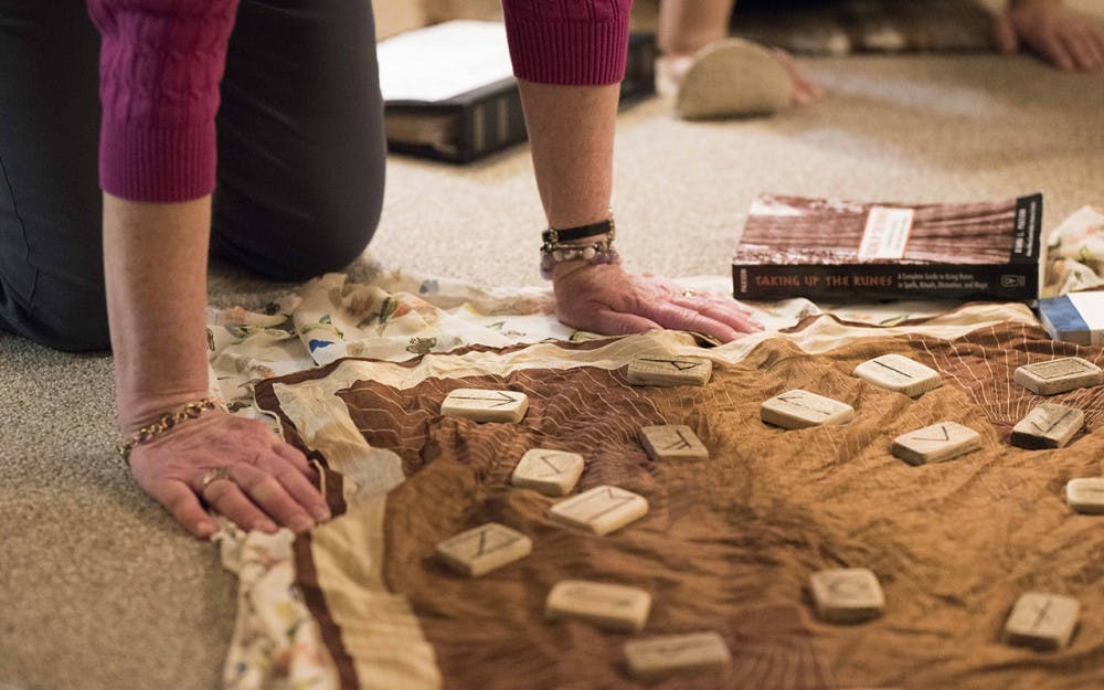 Jeanette Barefoot and four others summon the Nordic Rune, Uruz, at the Sunrise Hive tarot shop Monday night. The Uruz Rune was chosen randomly by a participant that felt called to pick it out of a basin, and the Rune is said to have raw power that must be bound with other Runes. 