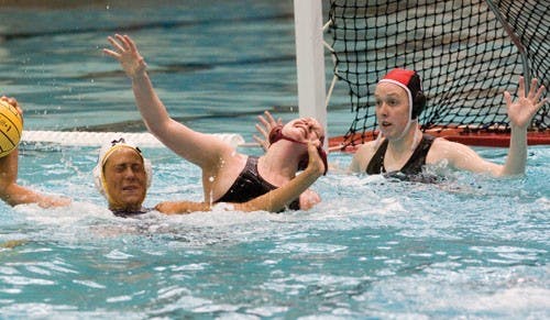 A player from Michigan University grabs freshman attacker Kelly Palmberg during a senior day match Saturday afternoon at the SRSC’s Counsilman Billingsley Pool.  The Hoosiers won 9-7 in overtime.