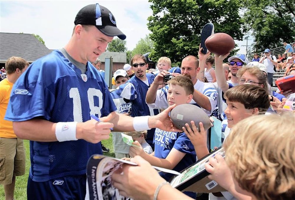 Indianapolis Colts quarterback Peyton Manning is surrounded by fans as he signes autographs before NFL football minicamp at Franklin College in Franklin, Ind., Saturday, June 6, 2009. 