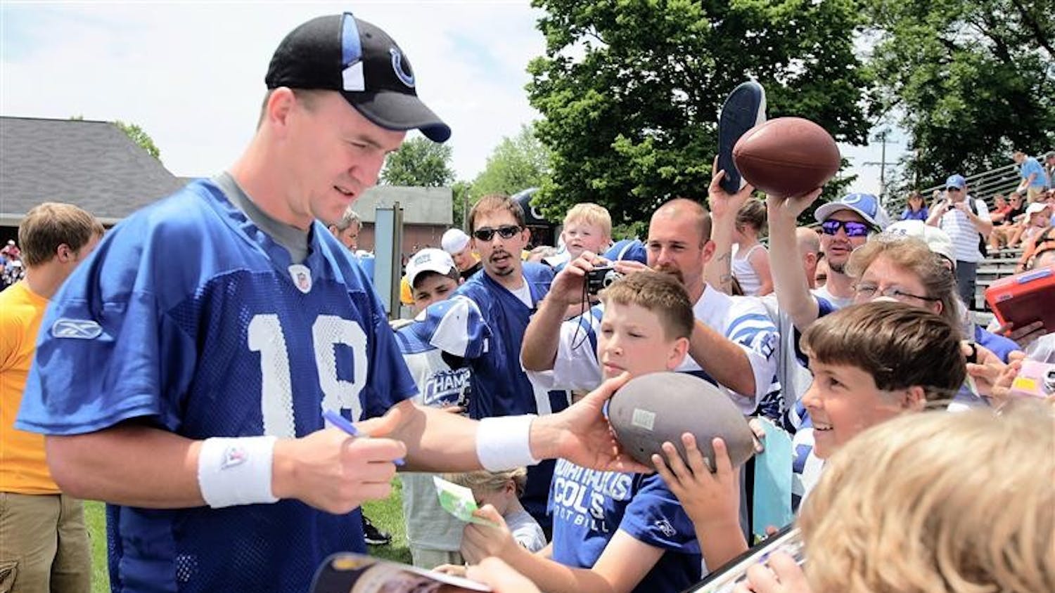 Indianapolis Colts quarterback Peyton Manning is surrounded by fans as he signes autographs before NFL football minicamp at Franklin College in Franklin, Ind., Saturday, June 6, 2009.