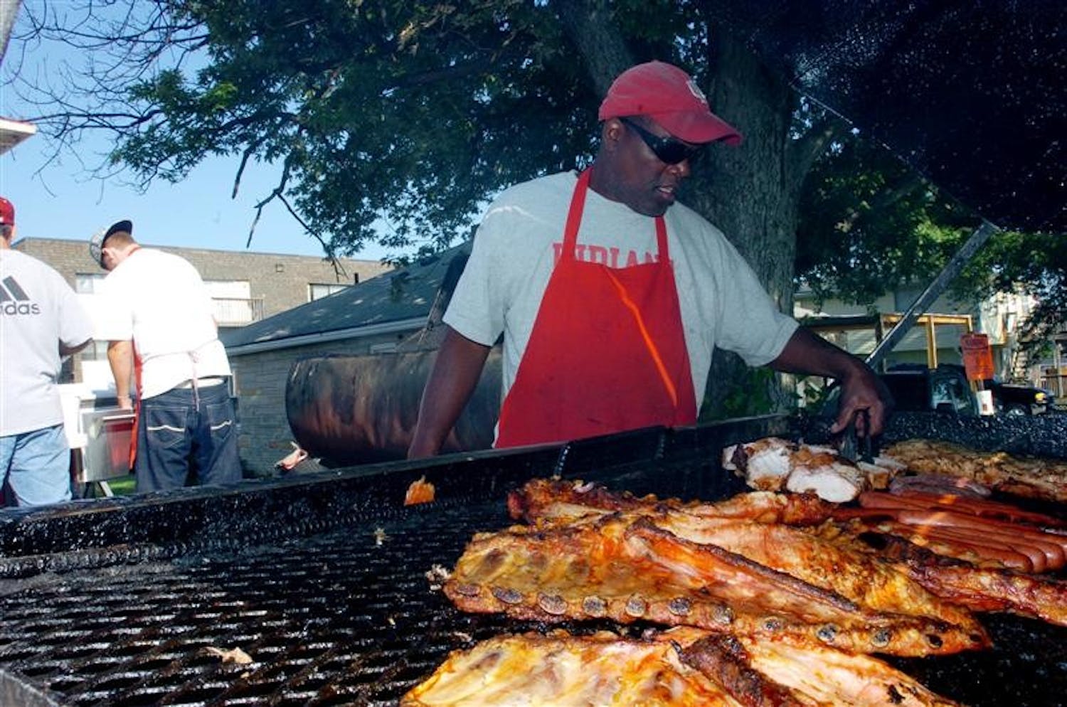 Will Thomas turns some meat on his grill prior to a football game between IU and Western Kentucky on Aug. 30 near Memorial Stadium.