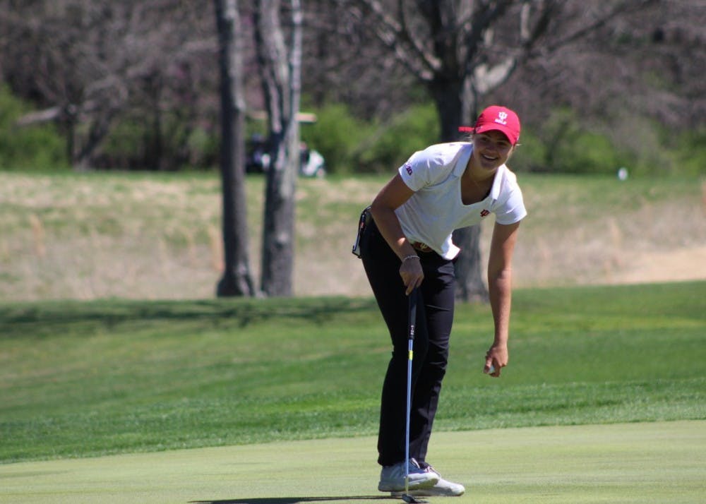 <p>Freshman Emma Fisher picks her ball out of the hole after sinking a putt on April 8, 2017, during the IU Invitational at the IU Golf Course.</p>
