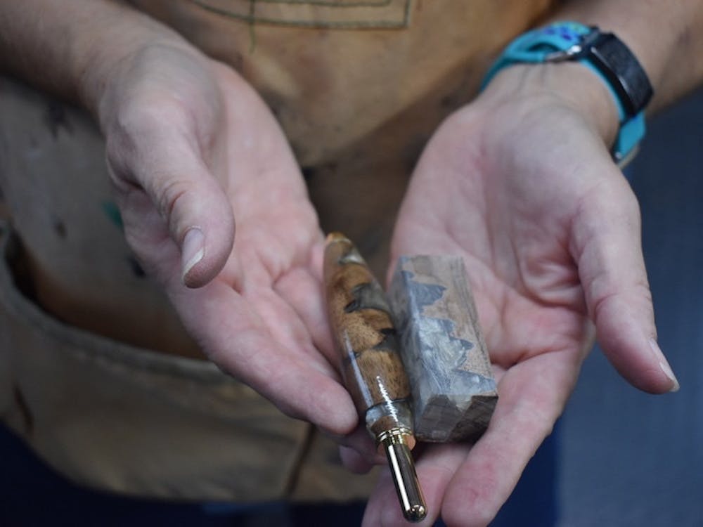 Alexis Pruitt shows a similar resin block that the seam ripper was sculpted from on Sept. 6, 2023, in her workshop. She said that the shapes emerge as she chisels and then sands for hours.