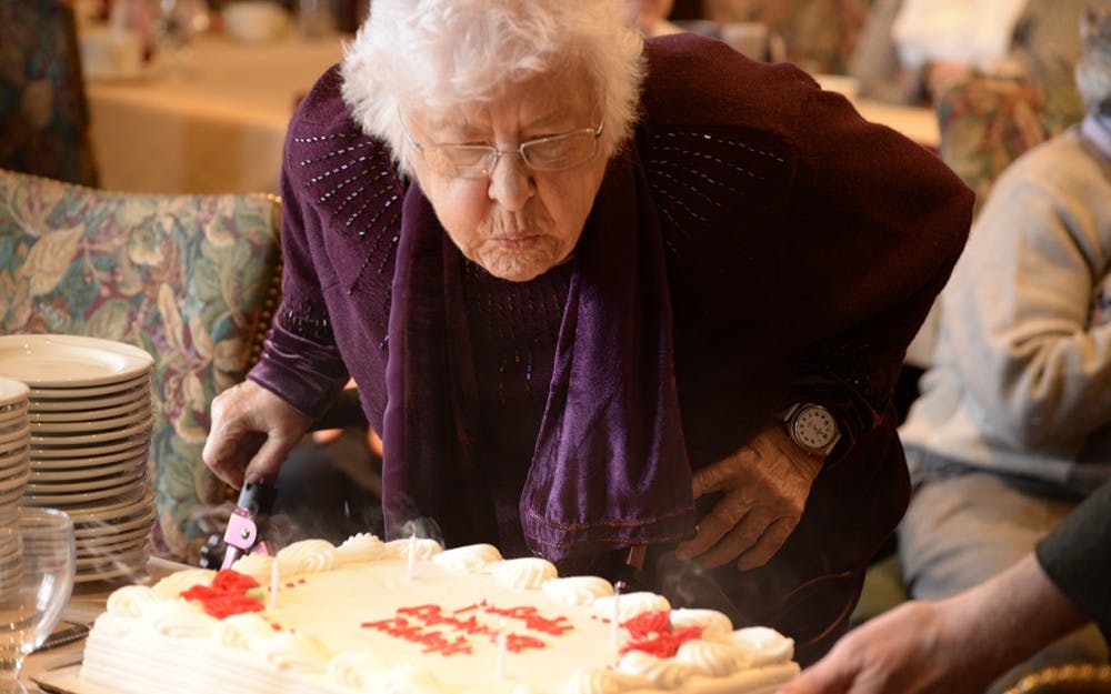 Marjorie Blewett blows out her birthday candles Monday afternoon in the Cornanation Room in the IMU. Members of the Bloomington Press Club presented her with a cake in celebration of her ninetieth birthday.