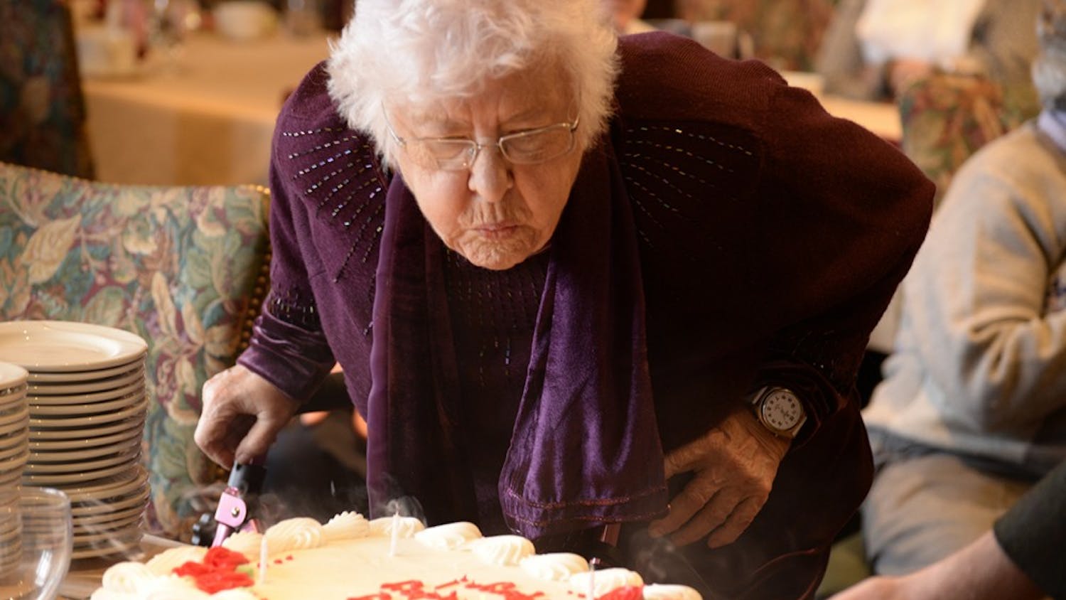 Marjorie Blewett blows out her birthday candles Monday afternoon in the Cornanation Room in the IMU. Members of the Bloomington Press Club presented her with a cake in celebration of her ninetieth birthday.