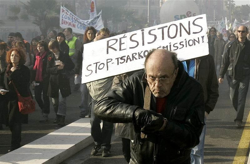 A French demonstrator holds a board reading in French: "Resist, stop, Sarkozy resignation!" during a demonstration Thursday in Nice, France. French workers fearful about the global economic crisis held a nationwide strike Thursday, shutting down train and subway lines, reducing staff at hospitals and leaving millions of schoolchildren without teachers.