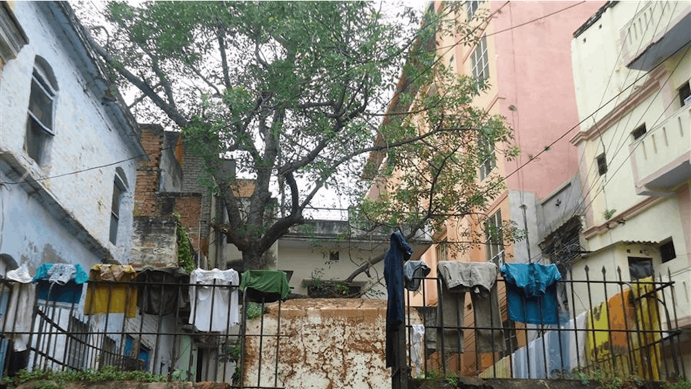 Clothes hang to dry on a gate surrounding the grave of a British officer from the colonial era.
