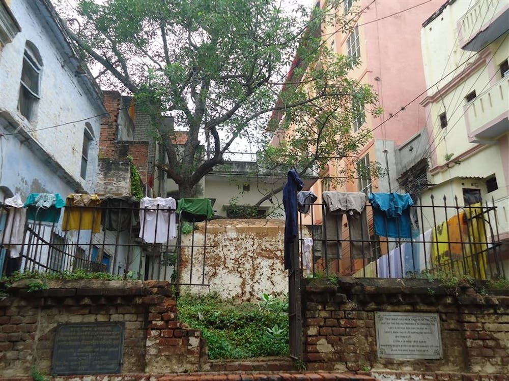 Clothes hang to dry on a gate surrounding the grave of a British officer from the colonial era.
