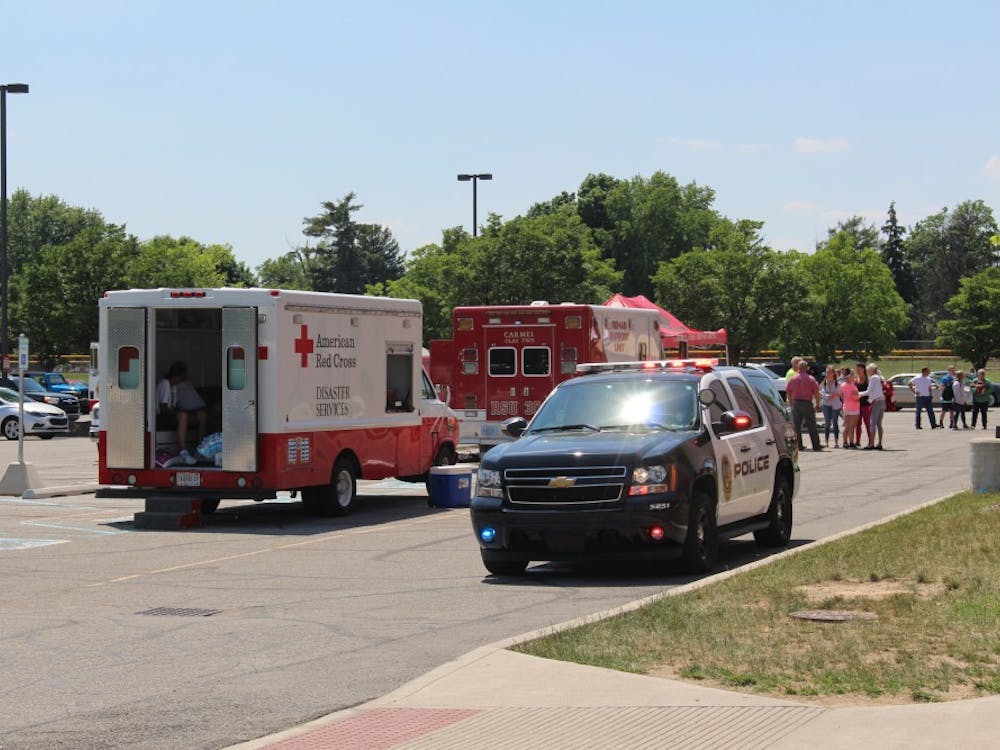First responder vehicles and volunteers stand outside Noblesville High School. After a shooting occurred at Noblesville West Middle School, leaving a teacher and a student injured, students from the middle school were transported to the high school to be picked up by parents.
