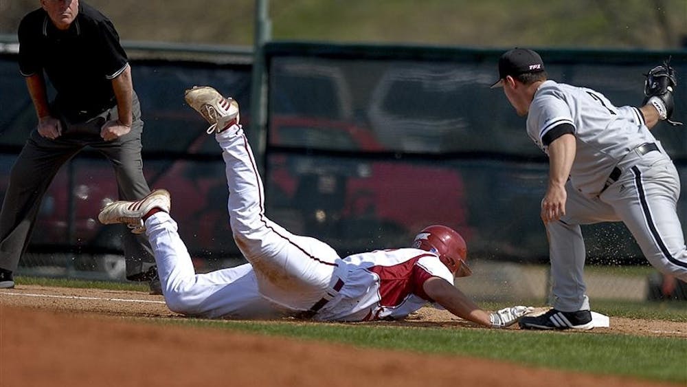 Now junior left fielder Alex Dickerson dives towards first base after a pickoff attempt during the Hoosiers' 5-4 loss to Louisville on March 30 at Sembower Field.