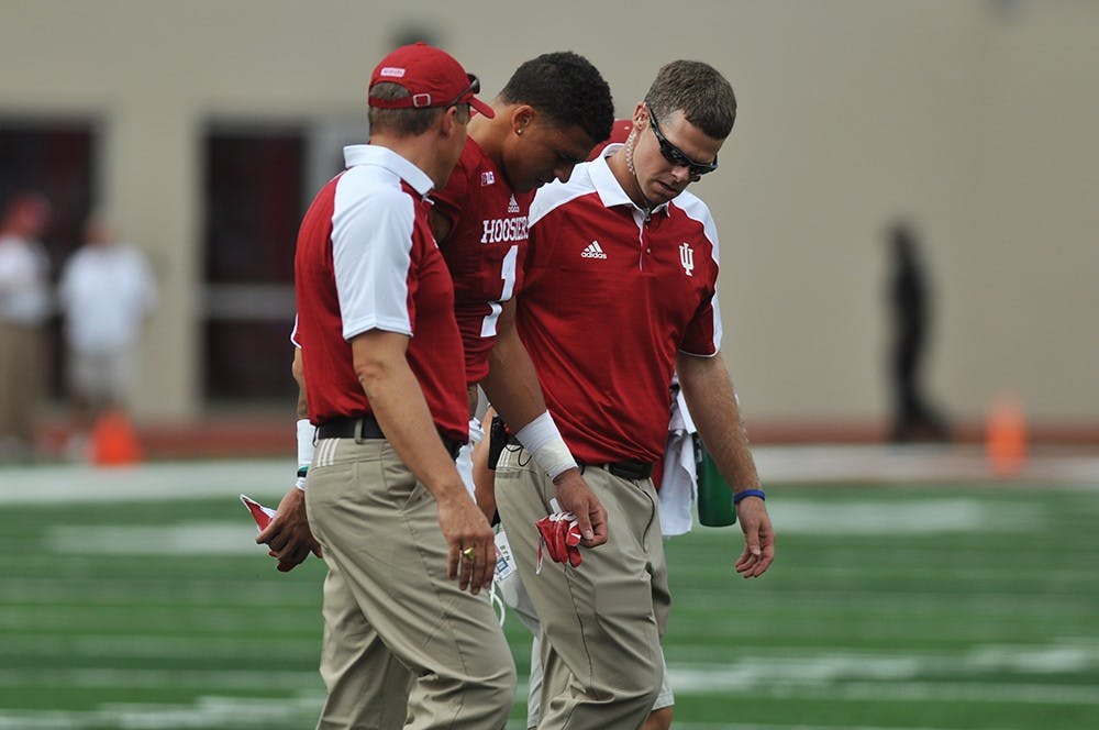 Junior wide receiver Simmie Cobbs is walked off the field at Memorial Stadium on Saturday after being injured during IU's game against Ball State. IU won 30-20.