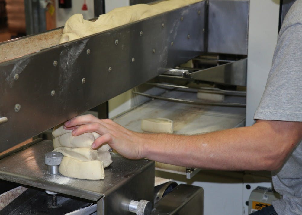 After letting the dough set on the table, it is cut into sections and put through a machine that shapes the bagels. Ratts removes the pieces that were not formed properly.&nbsp;