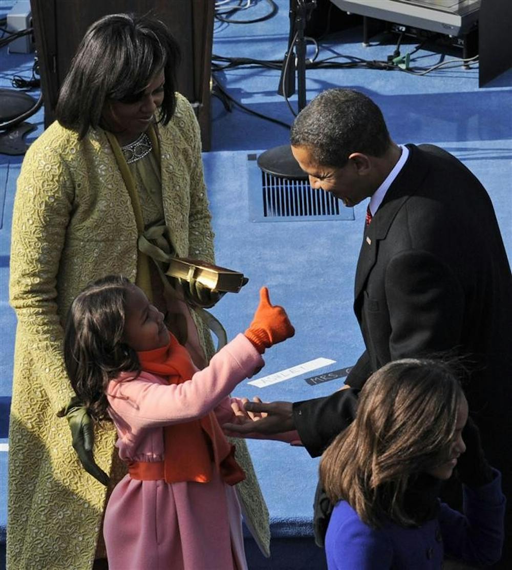 President Barack Obama, right, is congratulated by daughter Sasha, lower left, as first lady Michelle Obama looks on after Barack took the oath of office at the U.S. Capitol in Washington, Tuesday, Jan. 20.
