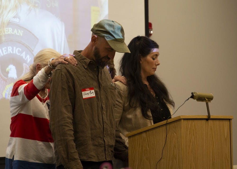 <p>Doug Mackey and his wife, Sarah Dye, are prayed over during a Grassroots Conservatives meeting Sept. 26 at the Ellettsville Branch of the Monroe County Public Library. Dye was invited to speak at the meeting about the issues surrounding her farm, Schooner Creek Farm, and the Bloomington Community Farmers’ Market. </p>