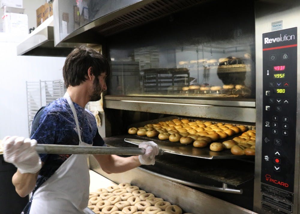 Bristow removes bagels from the oven after they are finished baking at 495 degrees. In his second year with BBC, Bristow said he likes that he can work at his own pace.