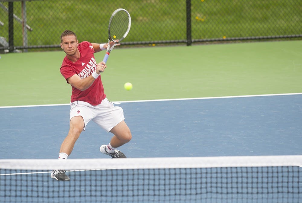 Senior Sven Lalic rushes toward the net to give a forehand return against Mateus Silva of Purdue University on Wednesday at the Varsity Tennis Courts. 