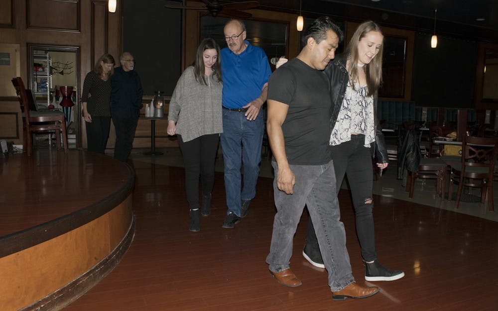 Attendees of the beginner tango class at Serendipity Martini Bar practice their walking in time to Argentine tango music Monday night. David Crosley, a guest teacher from Indianapolis, encouraged the dancers to go “inside the music.”