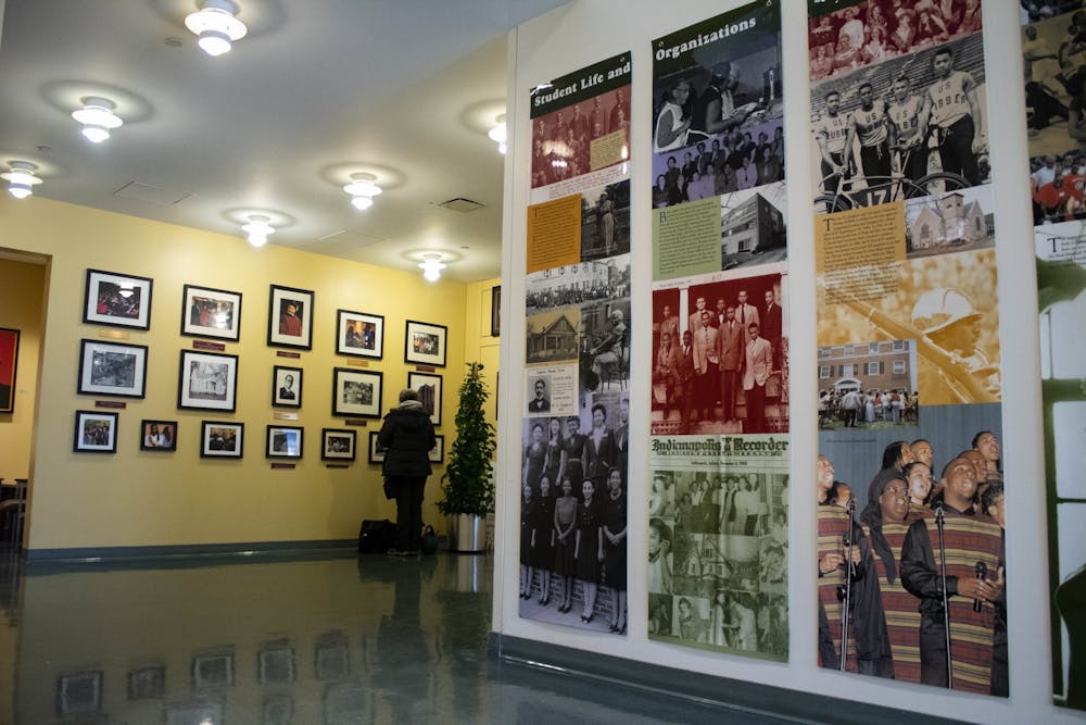 Students walk by the photographs on the walls Jan. 29, 2019, in the lobby of the Neal-Marshall Black Culture Center. The culture center will present the annual Umoja celebration virtually from Sunday to Friday.