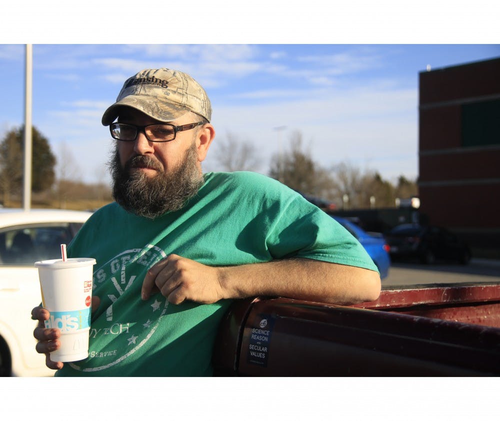 <p>James Mynatt stands next to a sticker stating, “Science reason and secular values,” on the gate of his truck. James leads a secular group at Ivy Tech Community College and prides himself on his outgoing and spontaneous personality.</p>