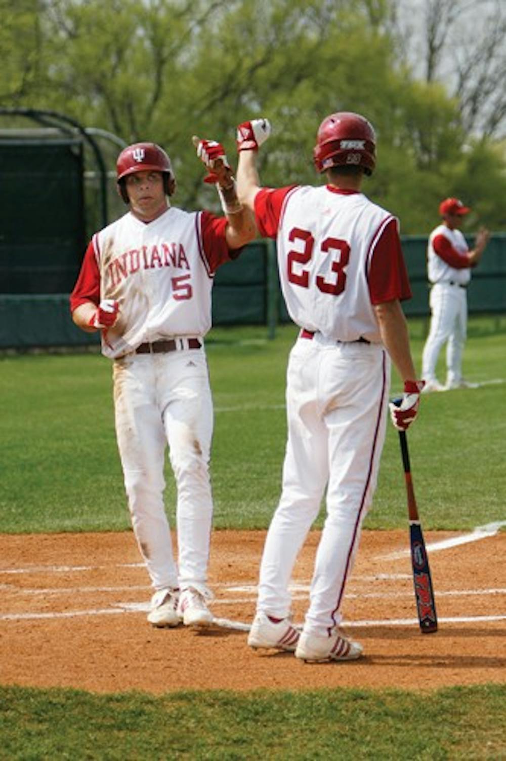 Brandon Foltz / IDS
IU junior outfielder Andrew Means (5) greets teammate Kipp Schutz (23) after scoring a run against Indiana State Wednesday afternoon at Sembower Field. The Hoosiers defeated the the Sycamores 7-2.