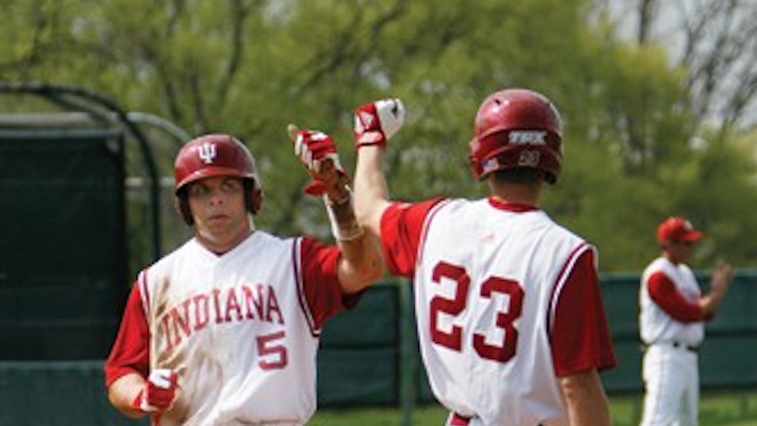 Brandon Foltz / IDS
IU junior outfielder Andrew Means (5) greets teammate Kipp Schutz (23) after scoring a run against Indiana State Wednesday afternoon at Sembower Field. The Hoosiers defeated the the Sycamores 7-2.