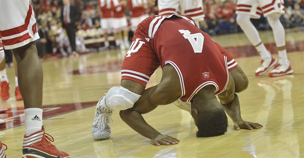 Sophomore guard Robert Johnson puts his head on the court after hearing the Hoosiers fouled Wisconsin on Tuesday at the Kohl Center. IU lost 82-79 in overtime.