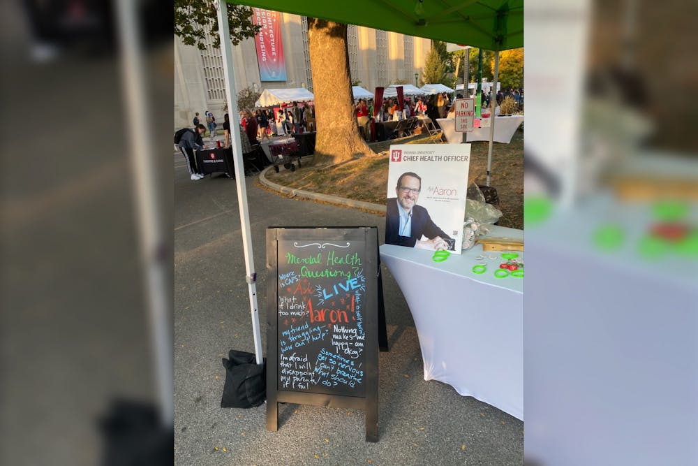<p>Signs promoting &quot;Ask Aaron&quot; are seen ﻿at the Office of the Chief Health Officer&#x27;s booth at First Thursdays on Oct. 6, 2022. IU announced its Student Mental Health Initiative in February, including a partnership between the Arts and Humanities Council and the Office of the Chief Health Officer.</p>