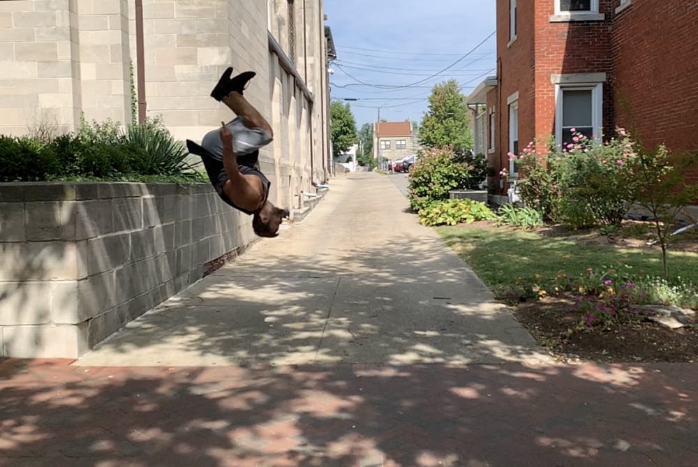<p>Parkour instructor James Brown demonstrates his backflip off of a wall Sept. 22 outside of the First Christian Church. This was the second parkour meeting Brown led. </p>