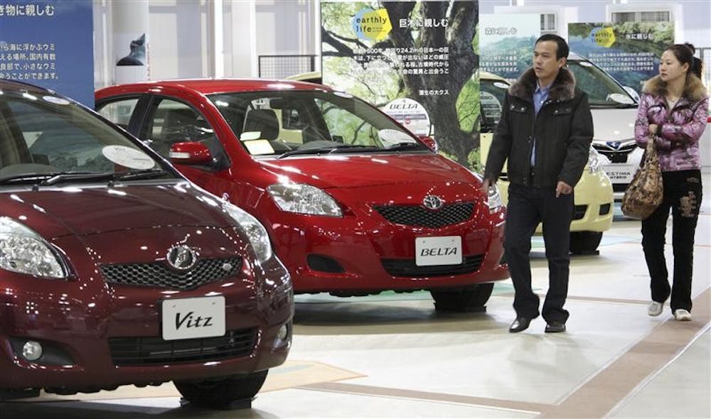 In this Dec. 26, 2008 file photo, visitors look at the latest models of Toyota Motor Corp vehicles at its gallery in Tokyo. General Motors sold fewer cars globally than Toyota last year, as the Japanese automaker passed the Detroit company for the first time.