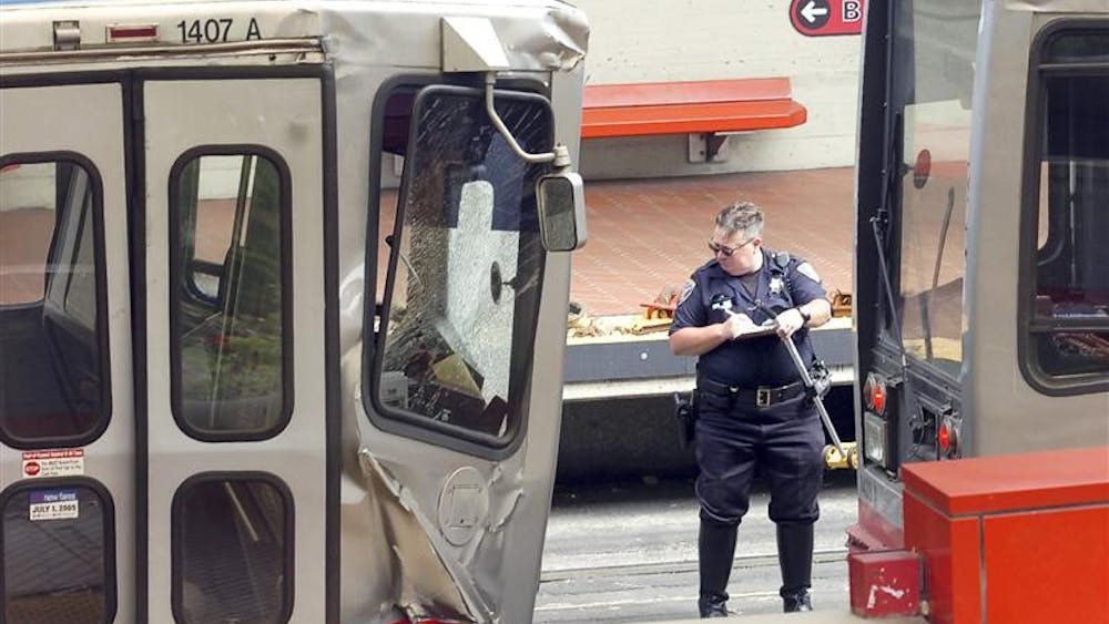 A police officer looks over the trains involved in a two train Muni crash at the West Portal Station in San Francisco on Saturday July 18, 2009. 