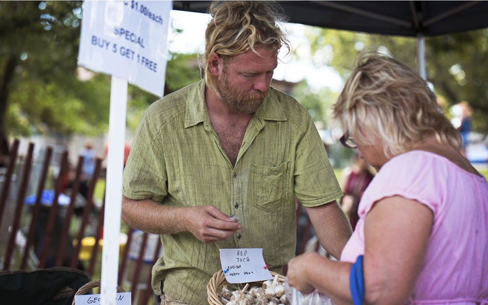 Micheal Hicks sells garlic at Garlic Fest on Saturday afternoon. Hicks grows his garlic on a farm in French Lick for the Living Roots Ecovillage. 