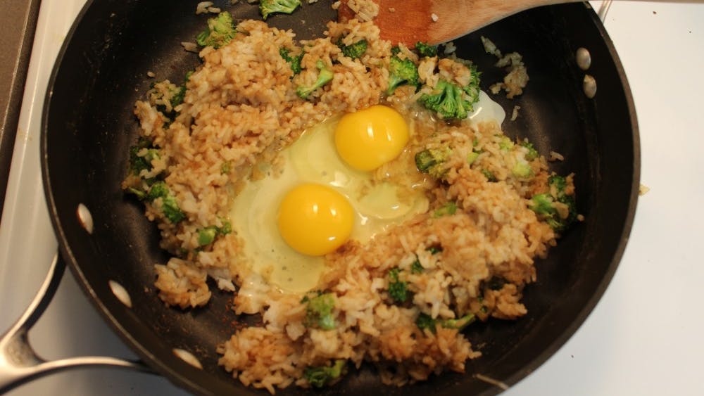 把鸡蛋打在米饭中间，然后迅速炒。
