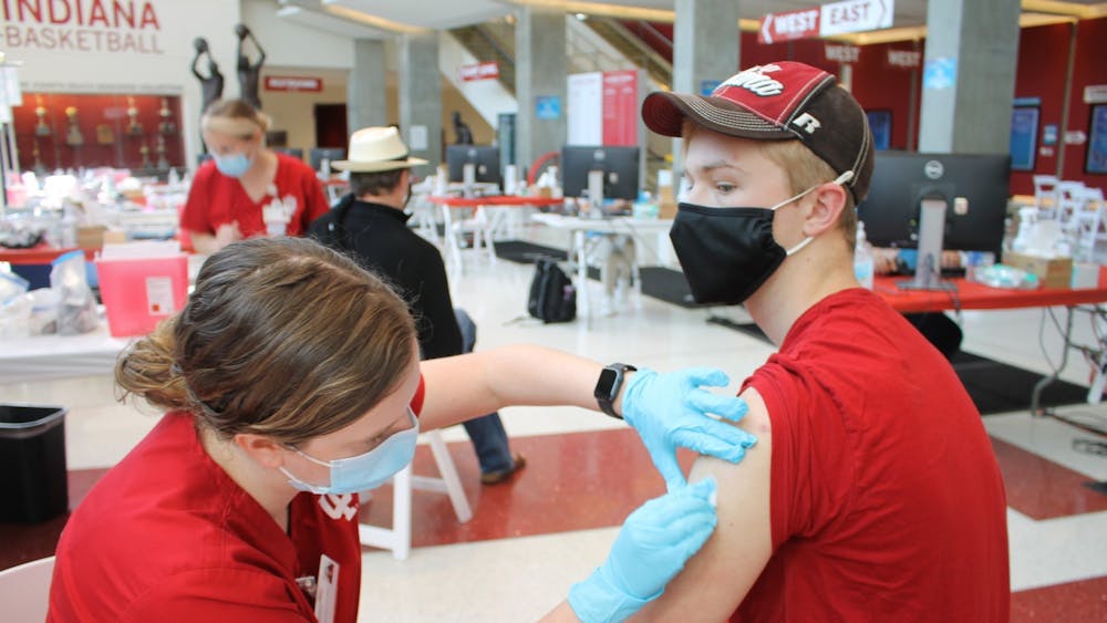 Then-junior Bryce Asher gets his first dose of the COVID-19 vaccine, administered by nursing student Maddy Anderson, April 12 in Simon Skjodt Assembly Hall.