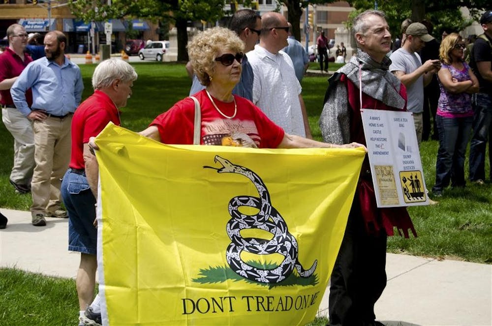 Greencastle resident Joan Billman holds a flag at a rally in opposition of a recent Indiana Supreme Court ruling prohibiting citizens from resisting police officers from illegally entering their homes Wednesday on the South Lawn of the Indiana Statehouse. Along with her husband Jack, Billman runs the Greencastle Defenders of Liberty, a Tea Party group.