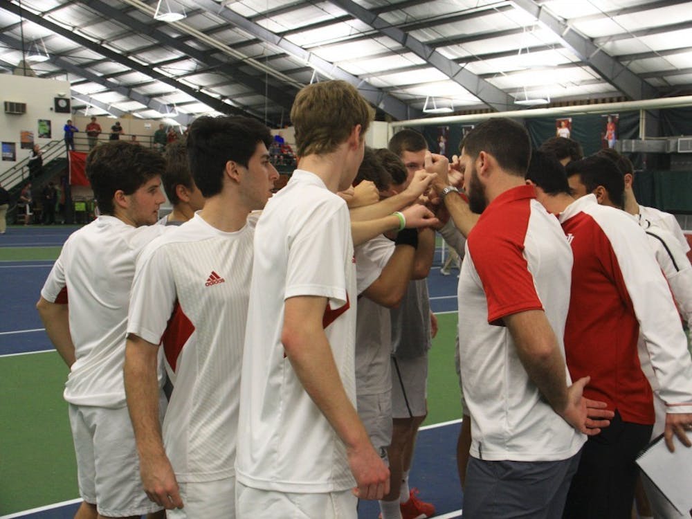 The IU men's tennis team gathers in a circle with coaches before a singles match against Purdue at the IU Tennis Center in April of 2017. IU split their two matches at the ITA Kickoff Weekend.