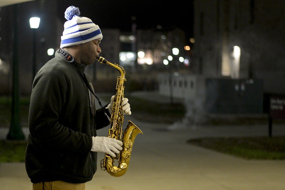Junior James Wilder plays his saxophone in the Cypress Hall breezeway on Thursday outside Union Street Center. Wilder, a jazz studies minor and member of the Marching Hundred, enjoys letting passersby recommend songs to play next. "I can play for hours, but I'd rather play something everyone knows so that you'll enjoy the experience with me," Wilder said.