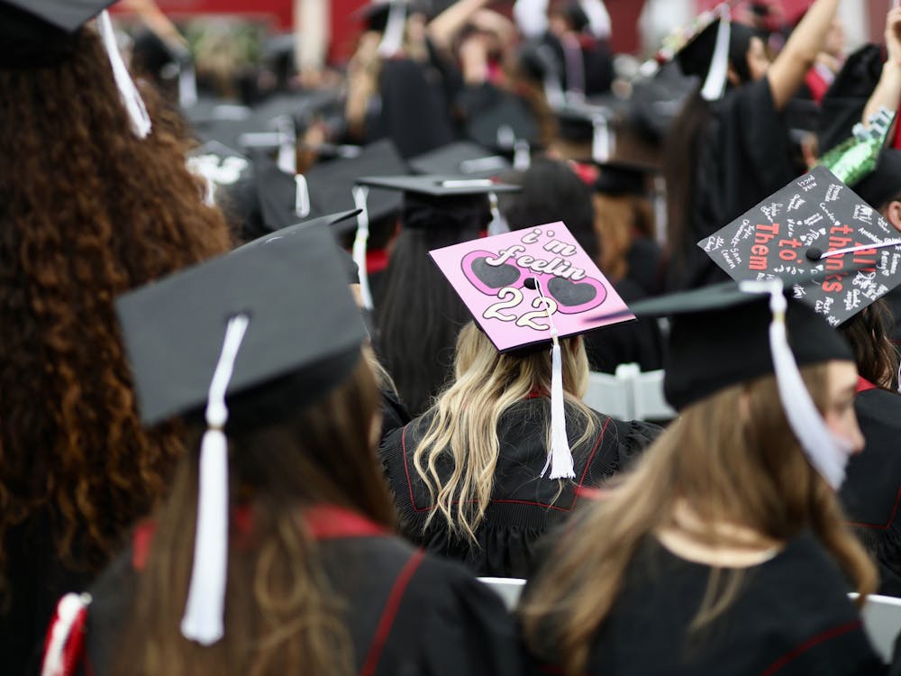 A student sits with a decorated cap at the 194th Undergraduate Commencement. IU honored more than 20,000 graduates in total across the state.﻿﻿