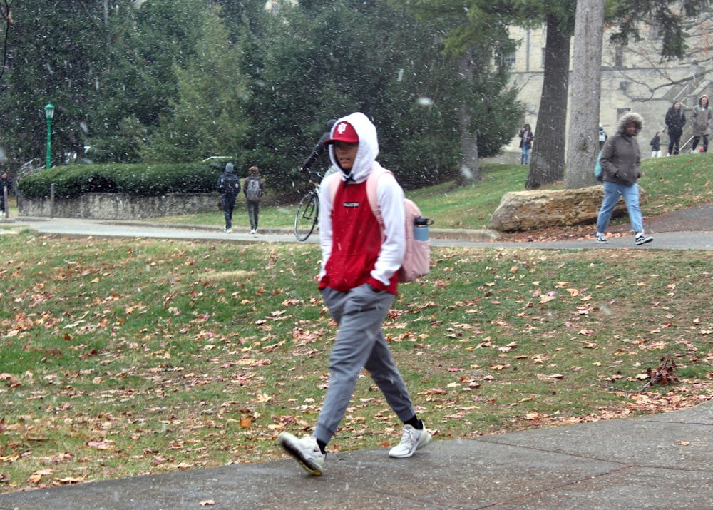 <p>An IU student walks to class on one of the first snowy days of the season Nov. 16, 2022. Layering up and staying dry is the most important thing to do when sleeping outside during the winter.</p>