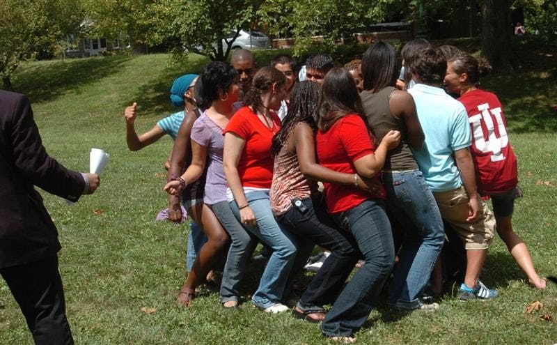 Hudson-Holland Scholars try to sit down and stand back up in a seated circle Wednesday in Dunn Meadow. The students also played ‘Never have I ever,’ came up with dances and performed them for each other.