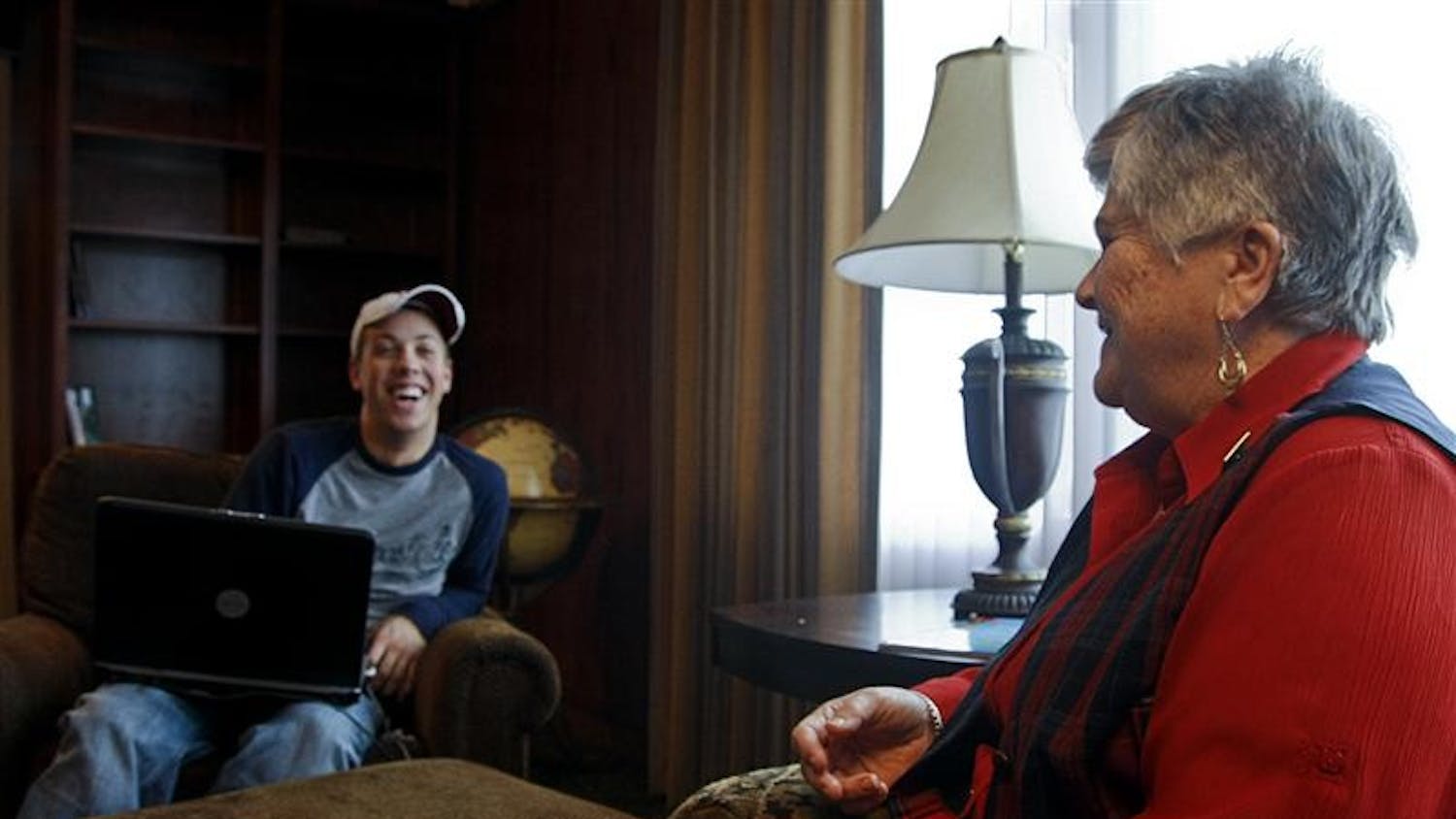 Patricia Lockwood, live-in house mom of the Sigma Phi Epsilon, right, sits and talks with sophomore Cory Mason on Wednesday afternoon at the Sigma Phi Epsilon house. Lockwood spends time talking with the men in the house, many of whom admit sneaking Tootisie Pops from the bowl next to her door.