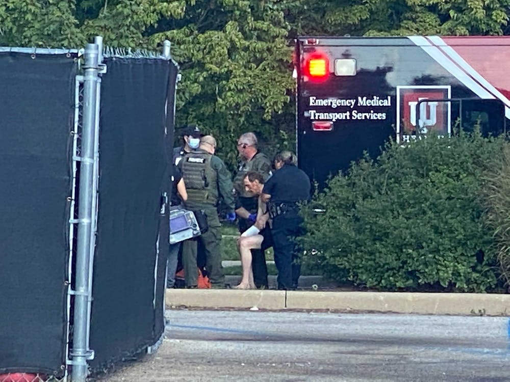 <p>The reportedly armed suspect, seated in the center, exited the sewer around 5 p.m. Tuesday after barricading himself there for over four hours. Partially clothed, he was escorted to an ambulance where police patted him down. </p>