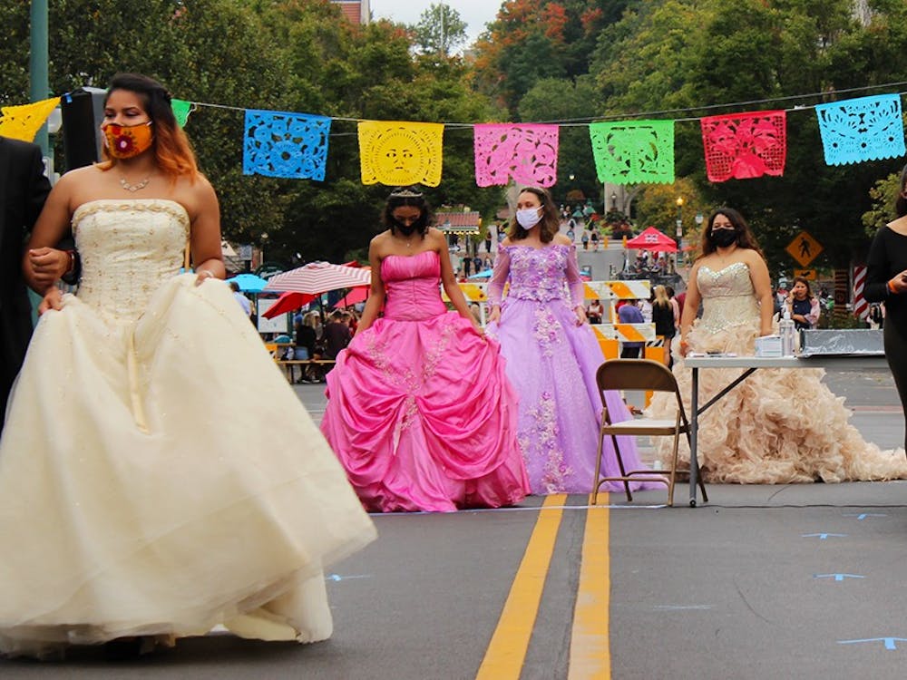 The quinceañera dress models circle around the runway Sept. 26 on Kirkwood Avenue. Several wear hoop skirts under their dresses to make the gowns puff out more.