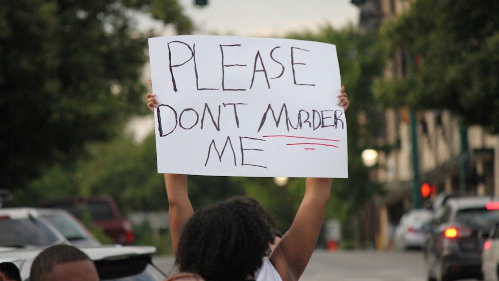 A protester holds up a sign June 1 in downtown Bloomington. Protesters marched through Bloomington in the wake of George Floyd&#x27;s death at the hands of Minneapolis police officer Derek Chauvin.