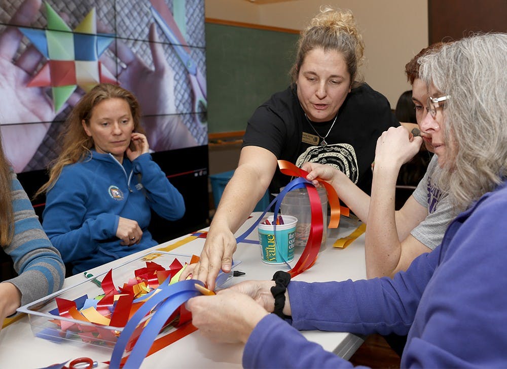 Loraine Martin, outreach director of the Lotus Education and Arts Foundation, teaches how to weave paper stars Monday at the Mathers Museum. Inspired by Dr. Martin Luther King. Jr, "1 Million Stars to End Violence" is an international and a local community project to weave 1 million stars for a display in Queensland, Australia, 2018 as courageous symbols to end all forms of violence. The organization plans to weave 10 thousands stars at the end of the year.  