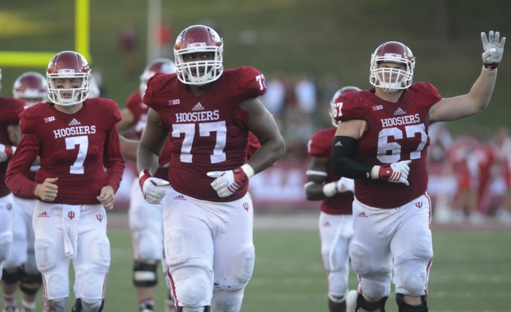 Quarterback Nate Sudfeld, offensive lineman Dimitric Camiel (77) and offensive lineman Dan Feeney (67) switch end zones and prepare for the fourth quarter during the game against Western Kentucky on Saturday at Memorial Stadium. The Hoosiers won, 38-35.