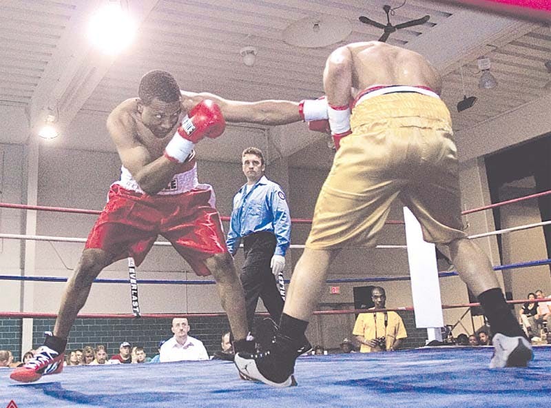 Abdul Blackburn punches Louis Brown as referee Eric Fetzer watches. Blackburn was defeated by Brown in the six-round bout.