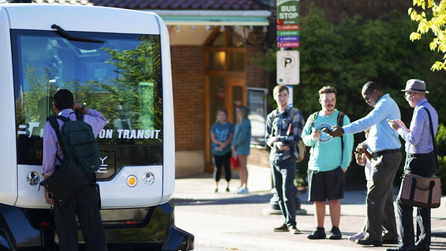 Pedestrians stop to peer into the self-driving bus and take pictures of it at its parked location on Kirkwood Avenue. EasyMile, a French autonomous vehicle maker, will be providing free rides in their EZ10 bus model to attendees on Friday from 10 a.m. to 4:30 p.m.