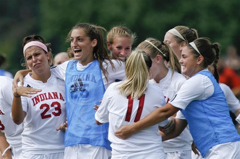 The IU womens soccer team celebrates with junior forward Kristin Arnold (11) following Arnold's goal-winning kick against Loyola Sunday afternoon at Bill Armstrong Stadium.